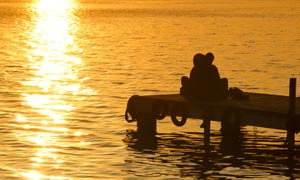 夕阳下在海边拥抱的情人摄影图片