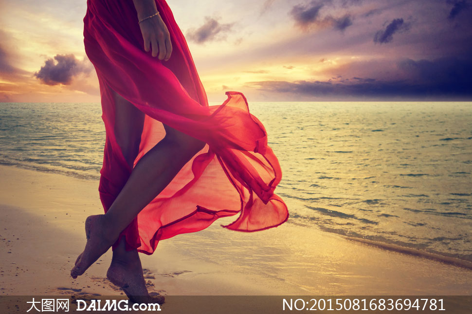 站在海边沙滩上的红裙美女高清图片