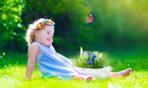 春天里坐在草地上的小女孩高清图片