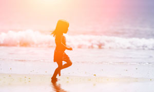 在海边滩涂上玩耍的小女孩高清图片