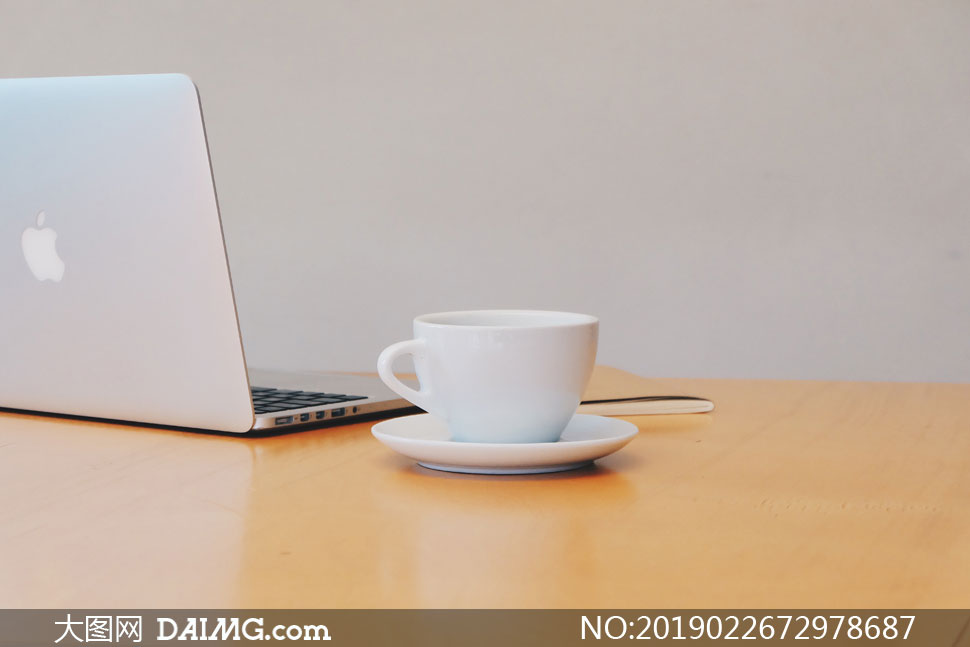 桌上的咖啡杯与笔记本电脑高清图片