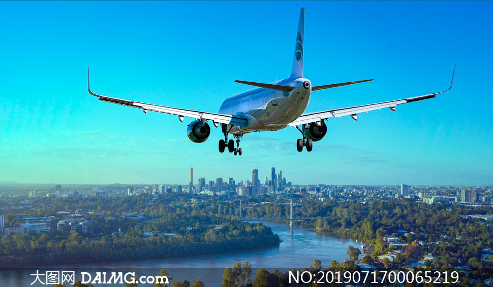 城市上空飞行的客机高清摄影图片