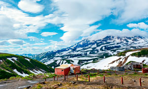 藍天下的雪山和房屋攝影圖片