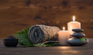 蜡烛与黑色的毛巾热石摄影高清图片