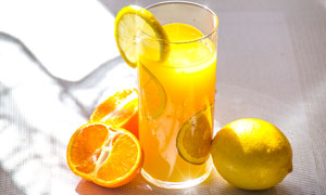 桌子上的一杯橙汁和柠檬摄影图片