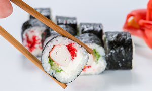 筷子夹起来的寿司美食特写高清图片