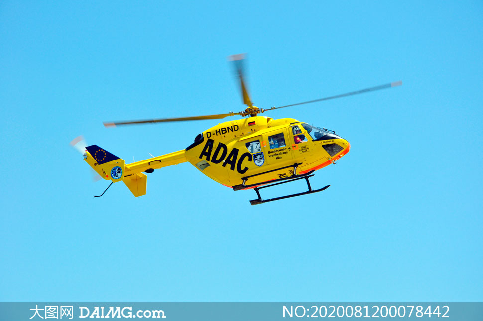 飞行中的黄色直升机摄影图片