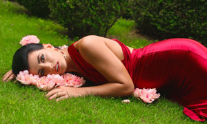 草地上身穿红色礼服的美女高清图片