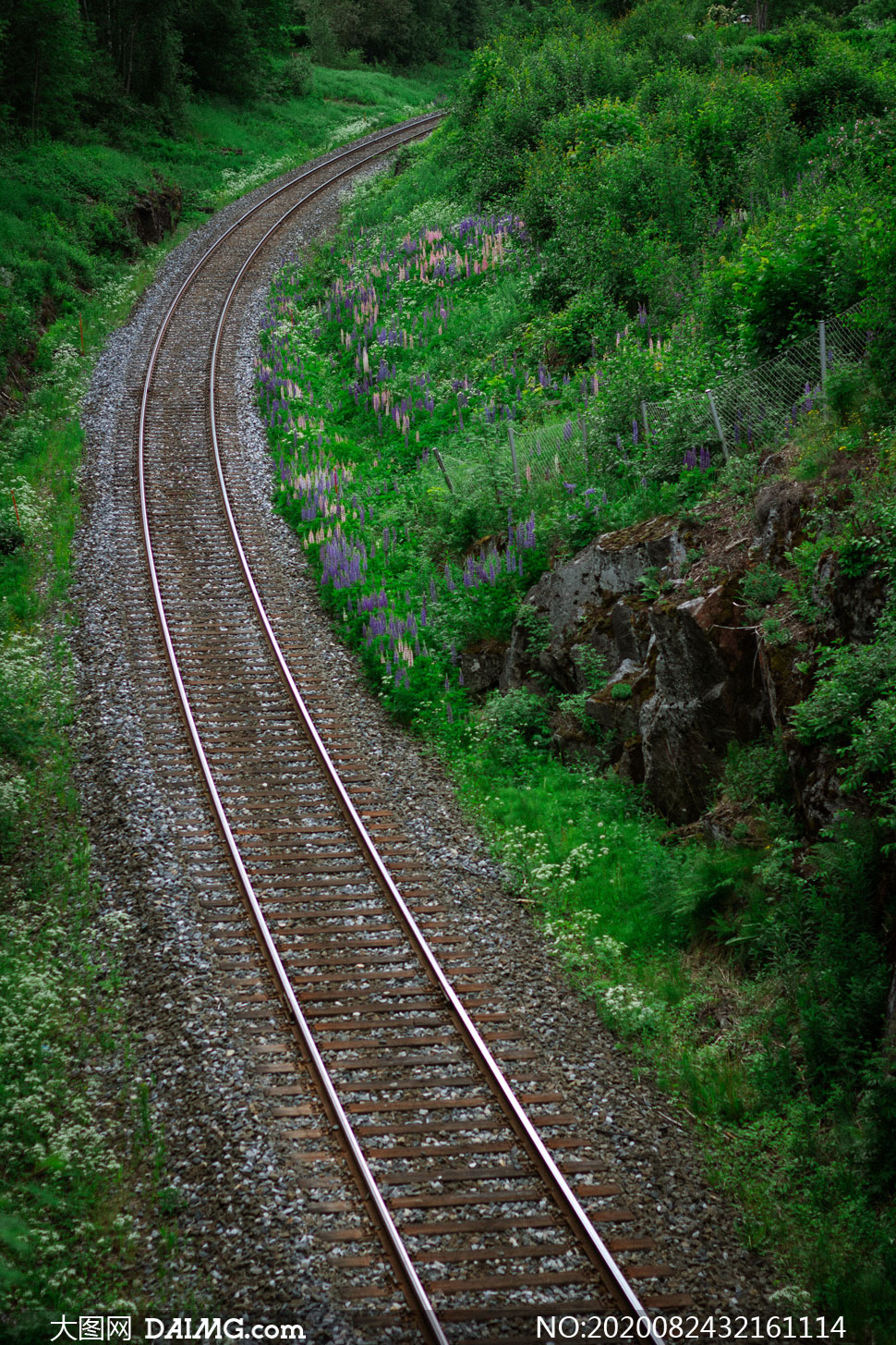 穿越山间青草地的铁轨摄影高清图片