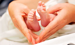 心形手勢中的嬰兒腳丫攝影圖片