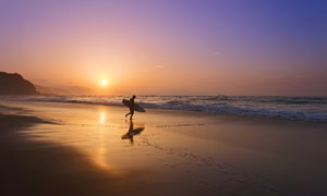 黄昏时分欲冲浪的男子摄影高清图片