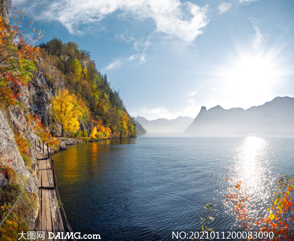 阳光下的湖泊和湖边栈道摄影图片