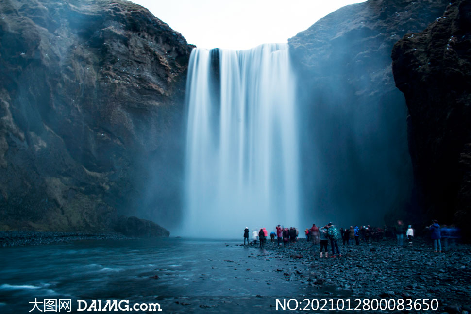 悬崖下观看瀑布的游客摄影图片_大图网图片素材