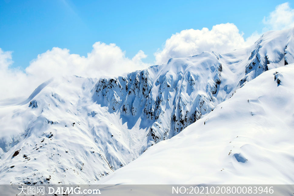蓝天白云下的雪山景观高清图片
