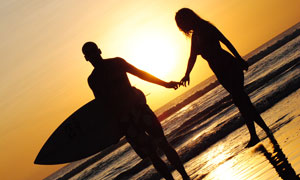 夕阳下载沙滩手拉手的情侣剪影摄影图片