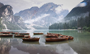 高山树林与湖上的船只摄影高清图片