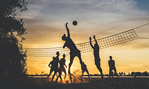在沙灘上打排球的人群攝影高清圖片