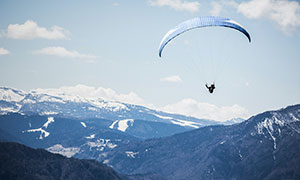 翱翔在山間上空的翼傘運動人物圖片