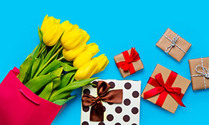 禮物盒與黃色的郁金香花朵攝影圖片