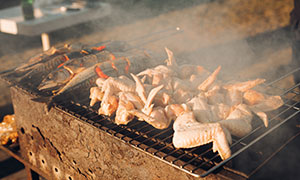 在烧烤架上烤制的鸡翅摄影高清图片