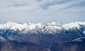 藍天白云下連綿的雪山景觀攝影圖片