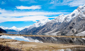 雪山腳下的湖泊景觀攝影圖片