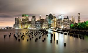海邊城市夜景和木樁特寫攝影圖片