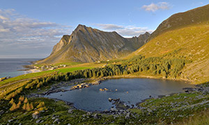 藍天大海與在山坡上的湖泊攝影圖片