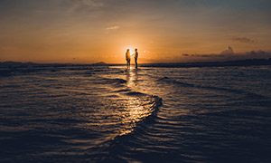 海边夕阳余晖中的情侣摄影高清图片