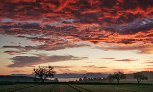 农田群山与天空中的火烧云摄影图片