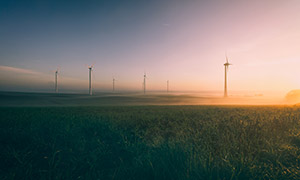 田野上的风力发电设施逆光摄影图片